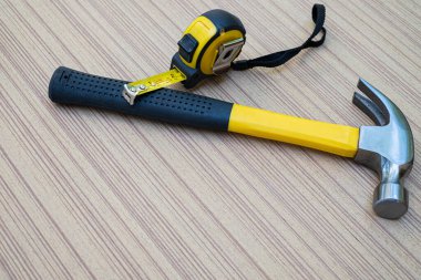 Çekiç ve mezura, marangoz için ahşap yaban domuzu üzerindeki el aletleridir.