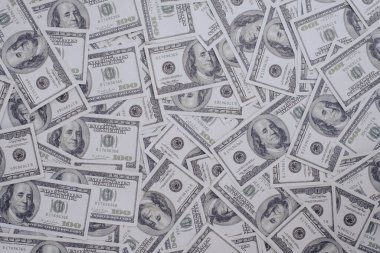 100 Amerikan Doları 'ndan oluşan bir grup banknot. Arka plan dokusunun çoğu, üst görünüm.