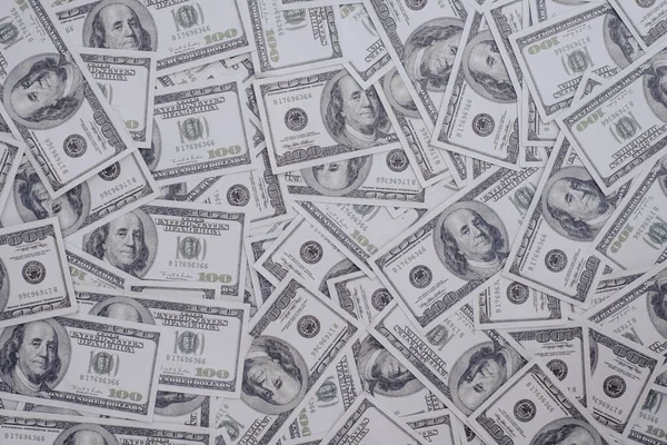 100 Amerikan Doları 'ndan oluşan bir grup banknot. Arka plan dokusunun çoğu, üst görünüm.
