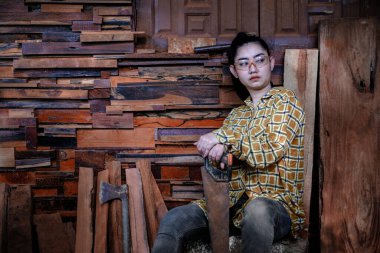 Marangoz kadınlar eski ahşap arka planda testereyle bekliyor.