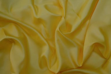 Pürüzsüz, zarif sarı ipek kumaş lüks kumaş dokusu arka plan olarak kullanılabilir