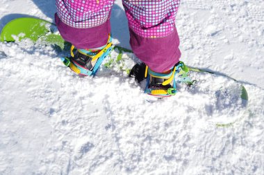 Khvalynsk, Rusya, Şubat 2021 Snowboard Kış Sporu. Küçük kız, kalın kışlık giysiler içinde karla oynuyor. Kış arkaplanı