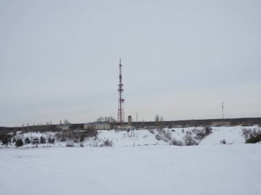 Karla kaplı viraj yolu, kışın Kuzey Kutup Dairesi 'nin kuzeyindeki köyün yakınındaki cep telefonuyla telsiz kulesine çıkıyor..