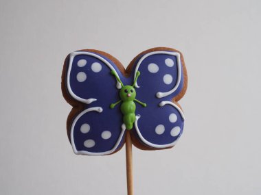 Kelebek şeklinde zencefilli kekler, kremayla kaplı ve pudra şekeri serpiştirilmiş.