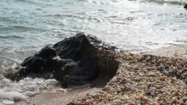 Deniz dalgaları sahil kayalıklarına vuruyor. Denizde kolay bir heyecan. Güzel deniz