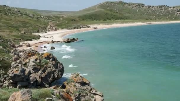 阳光明媚的海滩上的岩石山 — 图库视频影像