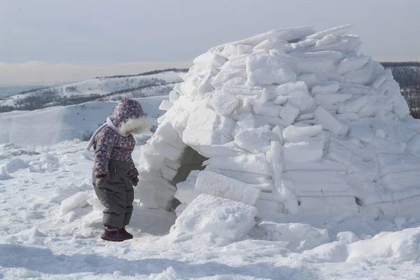 Dziecko Trzyma Kulę Śnieżną Squatting Przy Wejściu Domu Eskimosa Igloo — Zdjęcie stockowe