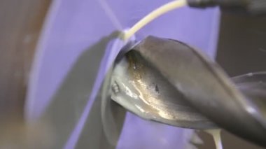 Torna tezgahı kullanarak metal bir atölyeyi delmek. Torna makinesi, metal şaft parçalarını kesiyor. Makineyi döndürerek yapılan metal işleme. Kapat.