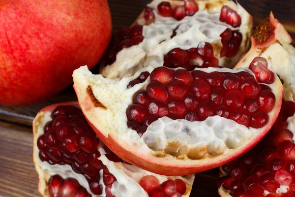 Rode sappige granaatappel, hele, halve, rijp en gebroken vruchten — Stockfoto
