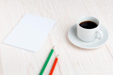 Fincan kahve, bir defter, kalem masada