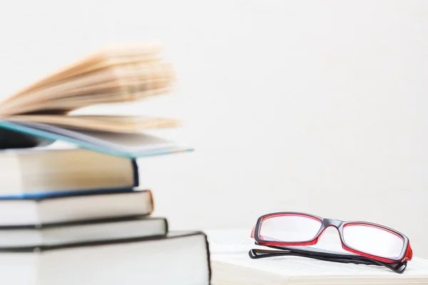 Libri impilati bicchieri sul tavolo Fotografia Stock