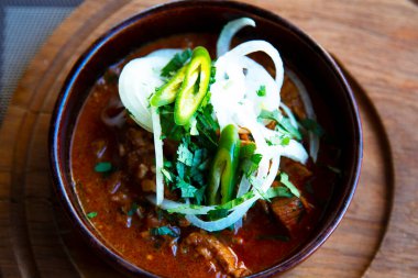 Kafkas mutfağı. Biftek, domates ezmesi, soğan, ahşap bir stantta seramik bir tabakta biber. Gürcü yemekleri servis eden bir restoran.