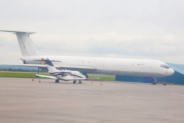 小飞机和大飞机并排站在机场的对比 — 图库照片
