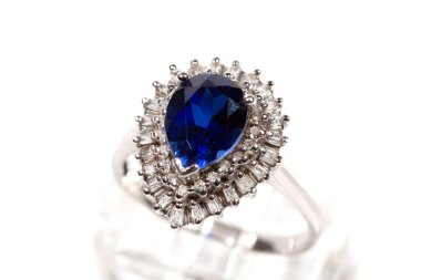 Elmas yüzük. Beyaz arka planda safirli elmas yüzük. Elmas ve büyük safir yüzüklü. Altın alyanslar.