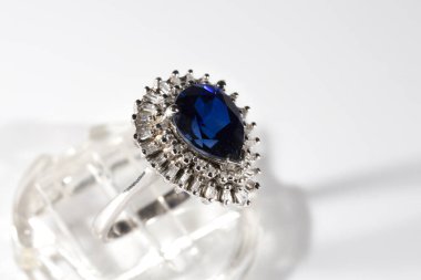 Elmas yüzük. Beyaz arka planda safirli elmas yüzük. Elmas ve büyük safir yüzüklü. Altın alyanslar.