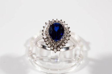 Elmas yüzük. Beyaz arka planda safirli elmas yüzük. Elmas ve büyük safir yüzüklü. Altın alyanslar.