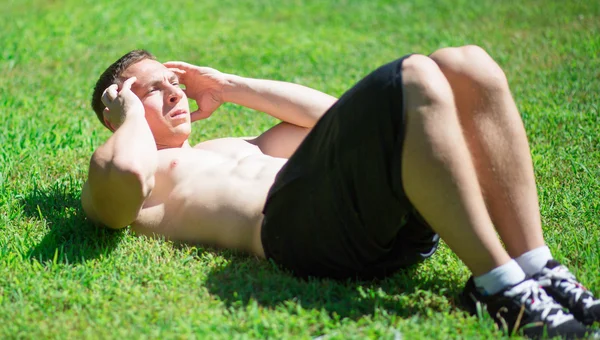 Young man doing crunches — Stock Photo, Image