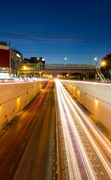 White headlights and red tail lights disappearing to the tunnel — Stock Photo, Image