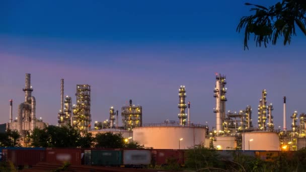 Lapso de tiempo de la destilación de la refinería de petróleo crudo a partir del suministro de carbono fósil con un gran tanque de almacenamiento detrás de la columna de destilación en la industria de refinerías de petróleo y economía petroquímica y transp de carga de tren — Vídeo de stock