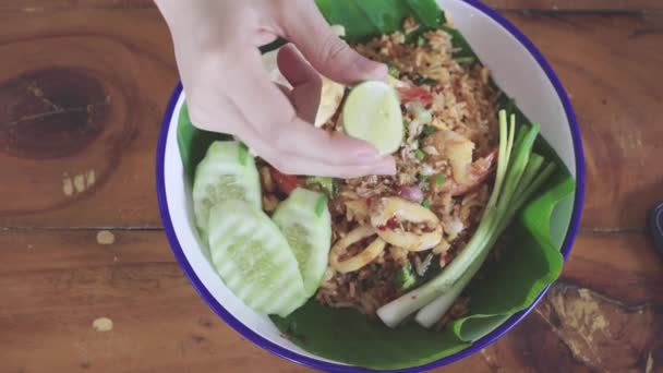 Femmina spremere acqua limone, lime, a frutti di mare gustosi freschi riso fritto con teste piccante da cibo delizioso in Thailandia, cibo tailandese — Video Stock