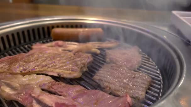 在宴会午餐上，在餐馆里的热烤箱里放上美味的牛肉烧烤牛排，并配上美味的烤火锅 — 图库视频影像
