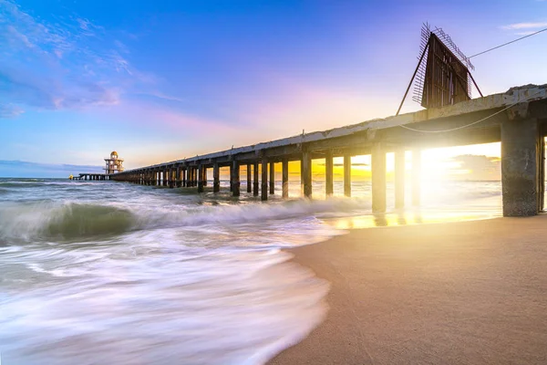 Prachtige Zonsondergang Gladde Oceaan Golf Het Strand Met Brug Haven Rechtenvrije Stockfoto's