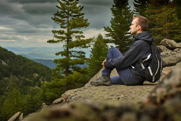 Portrait of sitting young man while hiking across macedonia mountains in prespa national park having pleasure with nice view — Stock Photo, Image