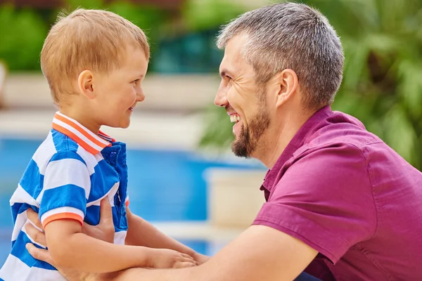 Father and son playing near water pool at the day time. Concept of happy family — Stock Photo, Image