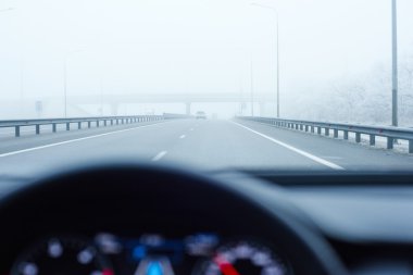 empty foggy road view from the modern car interior with dashboard