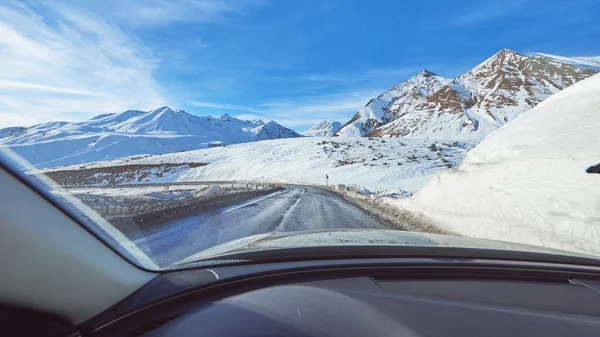snowy mountains road view from the modern luxury car interior
