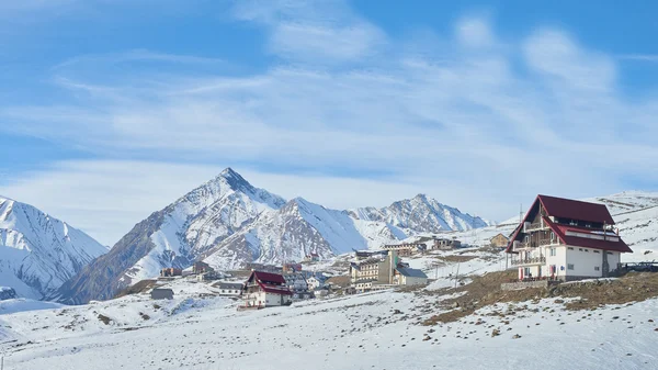 Modern mountains  ski resort with beautiful cottages with snowy peaks on the background in Georgia — Stock Photo, Image