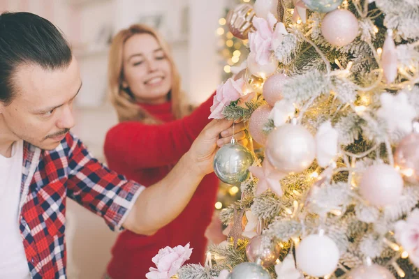 Christmas tree decorating young couple putting on xmas balls on green tree together — Stock Photo, Image