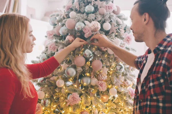 Christmas tree decorating young couple putting on xmas balls on green tree together — Stock Photo, Image