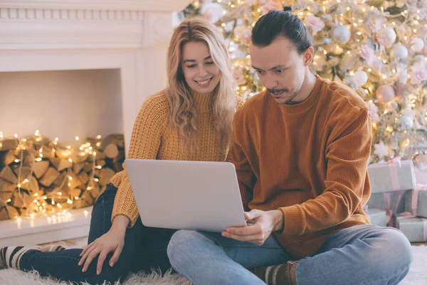 İnternetten Noel alışverişi. İnternet Dükkanına Kredi Kartıyla Mutlu Gülümseyen Çift. Bilgisayarlı ve kredi kartlı genç çift internetten alışveriş yapıyor. Noel hediyeleri. e-alışveriş