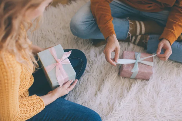 Egy pár közelsége, akik karácsonyi ajándékokat, ajándékokat cserélnek. Stock Kép