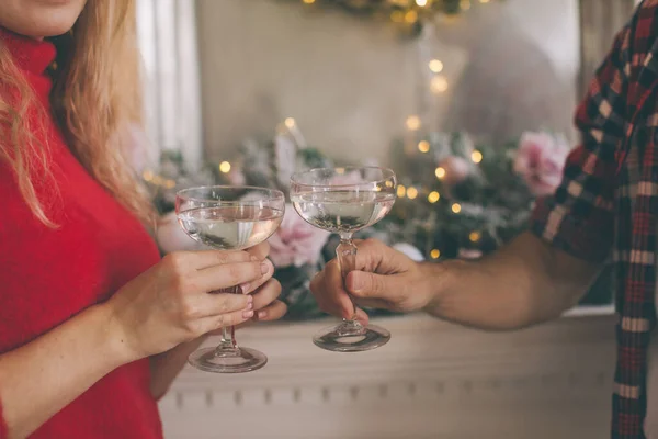 Young beautiful couple celebrating christmas at home in cozy clothes and drinking champagne — Stock Photo, Image