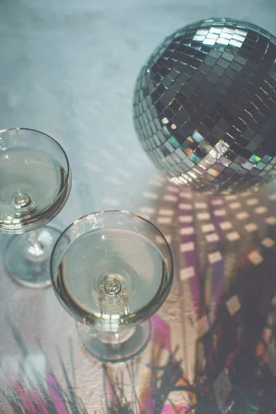 Copo de champanhe em um cupê com bola de discoteca e brilhos. Festa de Ano Novo, aniversário, dia das meninas ou outro evento de celebração — Fotografia de Stock