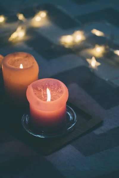 침대 위의 하얀 가짜 털 위에 놓인 나무 쟁반 위에서 촛불을 켜는 아늑 한 진짜 가정 장식 — 스톡 사진