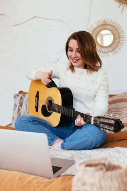 Kadın video kaydedicisi gitar çalarken kendini filme alıyor. Gitar dersleri online