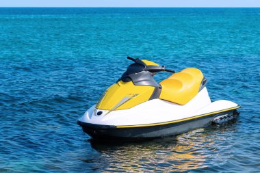 Mavi denize demirlemiş sarı beyaz jet ski. Hiç kimse, sadece jet ski. Bir jet ski üzerinde aktif dinlenme. Aşırılık
