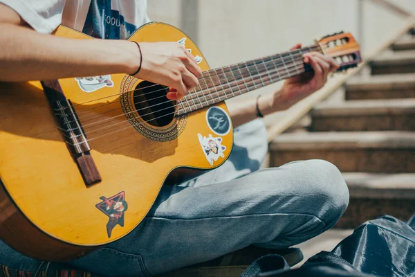 若いストリートミュージシャンがギターを弾いてお金を稼ぐ ストリートパフォーマーがギターを演奏 — ストック写真