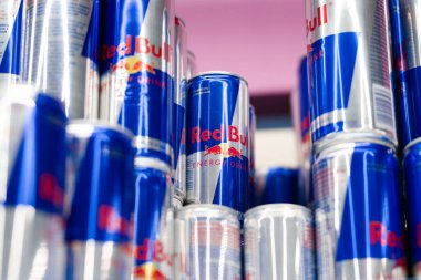 Brüksel, Rusya - 15 Aralık 2025: Süpermarket rafında yığılmış birden fazla kırmızı boğa enerji içeceği kutusu. Red Bull, Avusturyalı Red Bull GmbH şirketi tarafından 1987 yılında üretilen bir enerji içeceğidir.. 