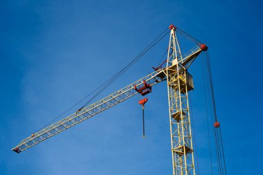 Açık mavi gökyüzünün arka planına karşı sarı inşaat vinci