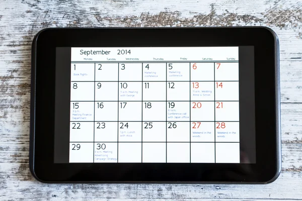 Kontrollera månatliga aktiviteter i kalendern i tablet — Stockfoto