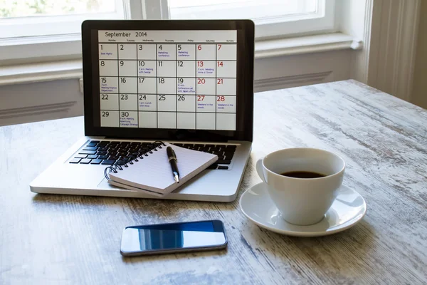 Comprobación de las actividades mensuales en el calendario en el portátil — Foto de Stock