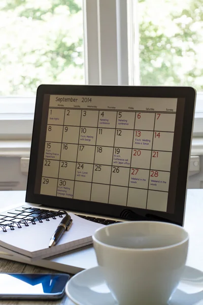 ラップトップでカレンダーの毎月の活動をチェックします。 — ストック写真