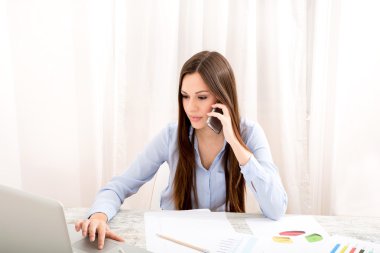 Telefonla konuşurken ofisinde çalışan