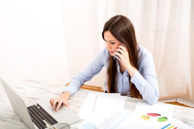 Ofiste çalışan ve telefonla konuşuyor