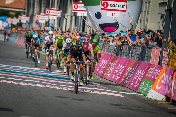 Pinerolo, Italia Mayo 26, 2016; Un grupo de ciclistas profesionales pasa la línea de meta de la etapa — Foto de Stock