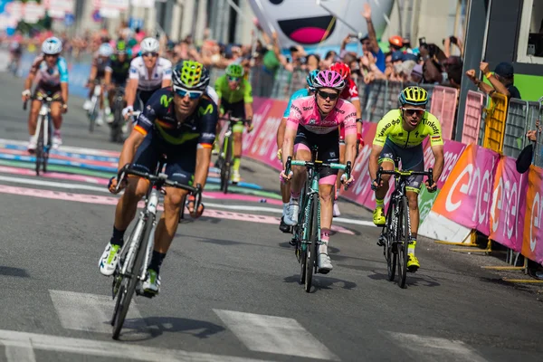 Pinerolo, Italia Mayo 26, 2016; Un grupo de ciclistas profesionales pasa la línea de meta de la etapa — Foto de Stock